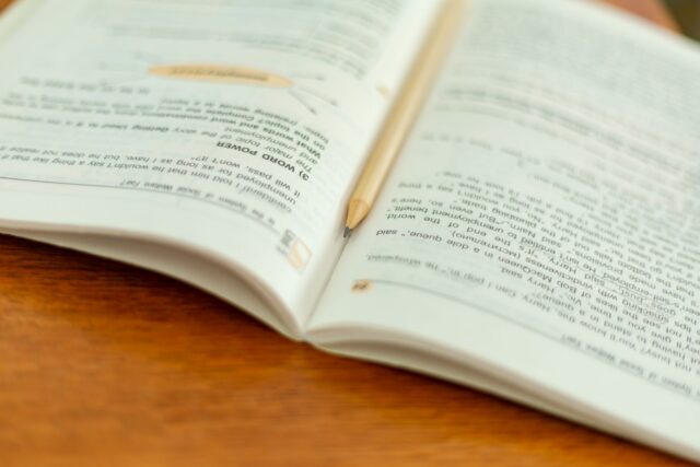 Caiet de matematică cu calcule rezolvate pas cu pas și un creion alături